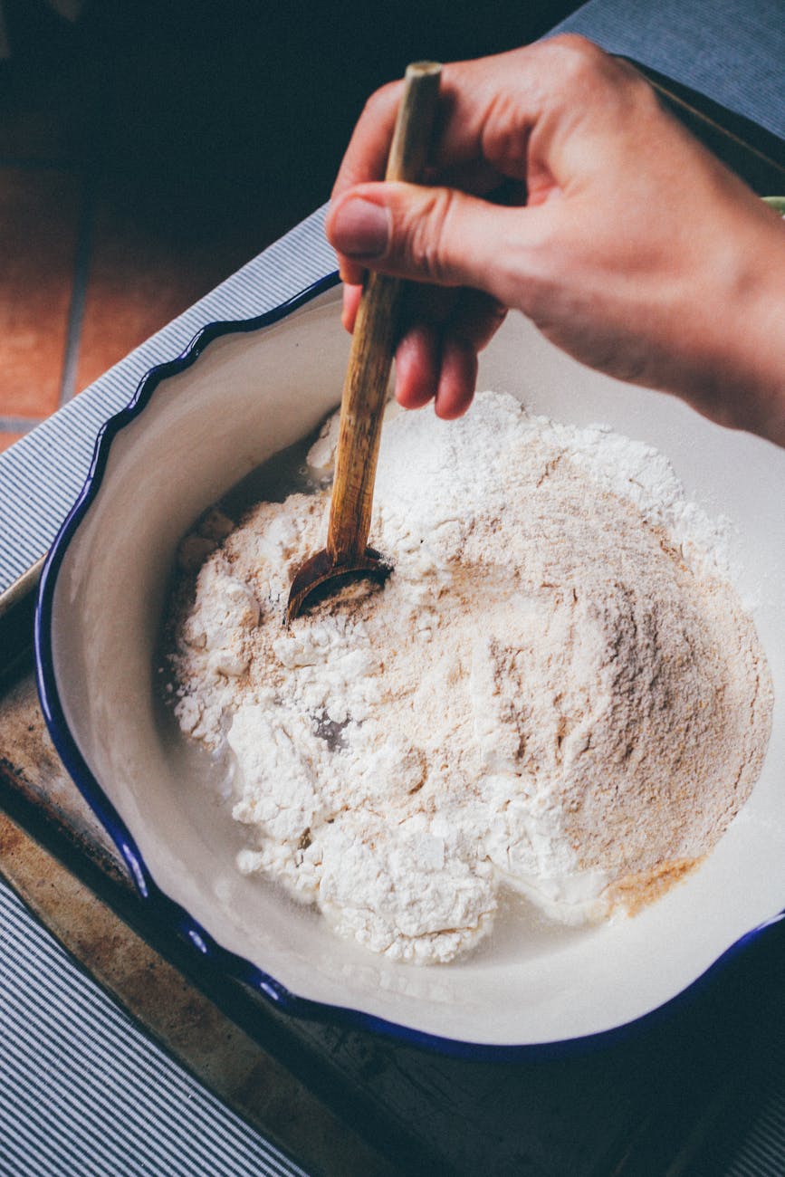 close up shot of a person mixing flour in a bowl